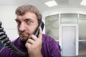  Adult bearded man speaks on the phone in the office