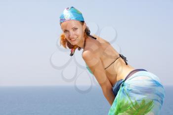 Smiling attractive woman in bikini and sarong on the beach
