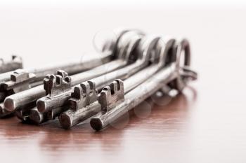 A closeup of bunch of old keys on wooden background