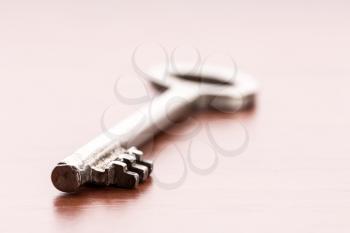 Macro of old key on wooden background