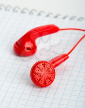 Red headphones over notebook vertical image