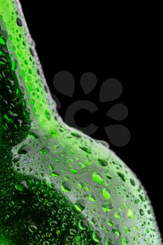 Wet green wine bottle closeup isolated on black