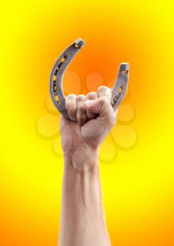 Symbol of luck. Horseshoe in hand against gradient background