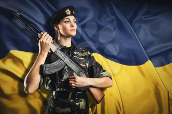 Soldier woman in uniform on the Ukraininan flag background