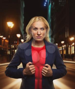 Strong woman superhero showing off her strength in night city street