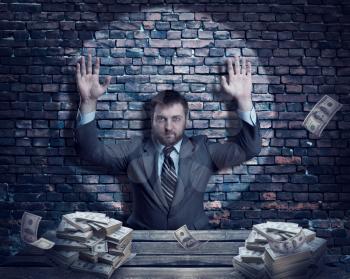 Businessman with heaps money over brick wall