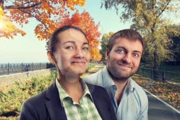 Happy man and woman in autumn park