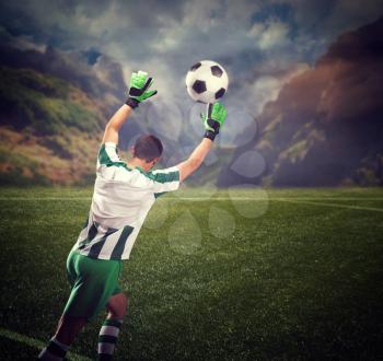 Back view of the goalkeeper catching the ball on the field in mountains