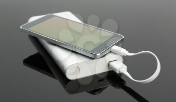 External power bank connected with a smart phone on the table