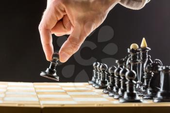 Close up of man's hand playing chess