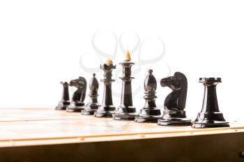 Black chess figures on the board ready to fight. Isolated