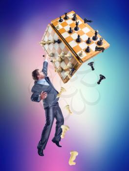 Businessman holding chess set and chess board above himself