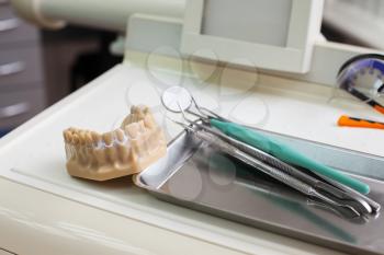 Dentist instruments and artificial jaw on the table