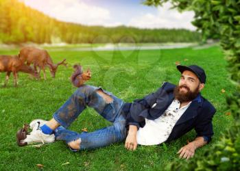 Happy vagrant lying on the lawn with animals
