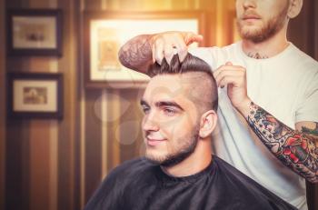 Young man having hair dress, barber fingers in the hair