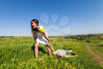 Woman pulling a slapped man after a picnic on nature