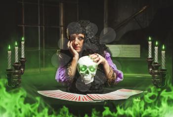 Sorceress practises witchcraft using the skull, green smoke in the room