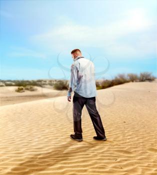 Injured businessman walking in the desert