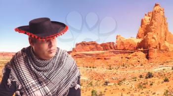 Serious man in sombrero in the desert