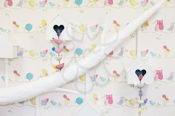 Decoration with white tree and nesting boxes with rag birds hanging on the wall. Interior playroom concept.