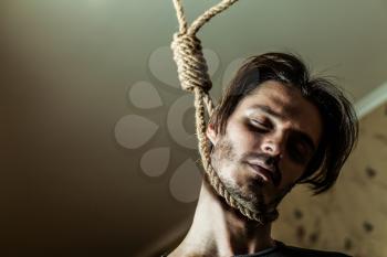 Suicide concept, depressed man with a noose around his neck.
