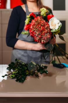 Female florist with beautiful bouquet of flowers in shop.