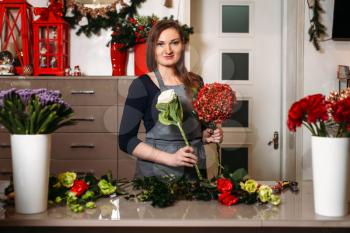 Female florist create beautiful bouquet in flower shop.