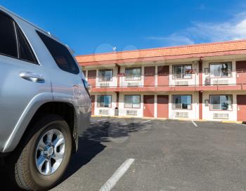Typical american inexpensive road motel with parking and separate rooms. Car travelling concept.