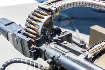 Closeup of helicopter machine gun with the loaded tape of bullets.