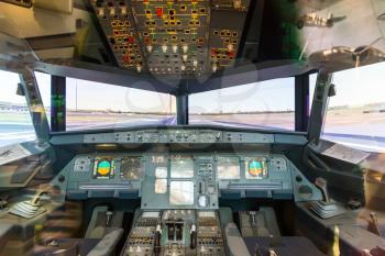 Inside airplane pilot cabin. Avionics dashboard, steering wheels, windows