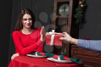 Shy woman refuses gift in restaurant. Couple relationship