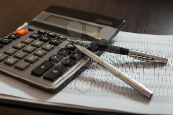 Accounting documents, pens and calculator on the table closeup