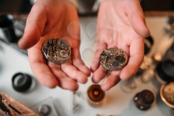Watchmaker hands holding antique pocket watch, show the clockwork mechanism closeup