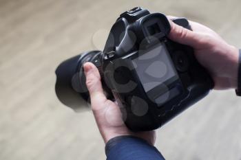 Male photographer hands holding digital camera, selective focus