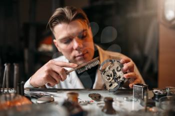 Watchmaker cleans the mechanism of old watches. Clock maker at work