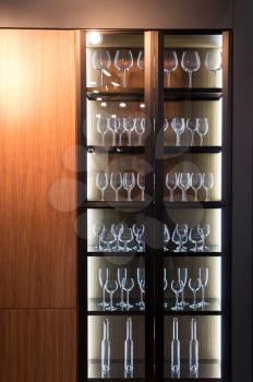 Wooden cupboard with glasses, interior dish decoration. Kitchen, restaurant or bar furniture