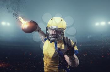 American football player with burning ball on the stadium. National league, men sport