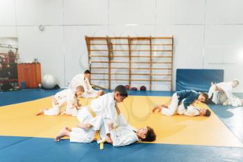Kid judo, children on fight training, martial art, self-defense. Little boys  in uniform in sport hall, young fighters