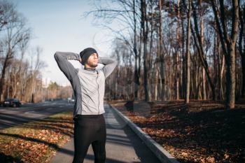 Male athlete on fitness workout outdoors. Runner in sportswear on training in park. Jogging or running