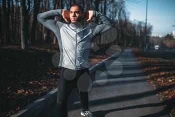 Male athlete on fitness workout outdoors. Runner in sportswear on training in park. Jogging or running