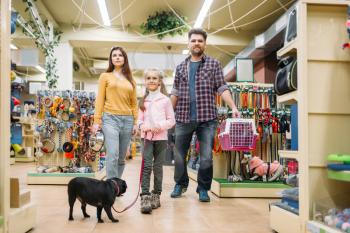 Happy family buying supplies for little puppy in pet shop. Father, mother, dauther and dog in petshop