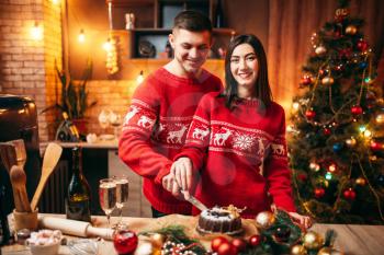 Happy love couple tastes christmas cake, festive food. Xmas celebration together, young family happiness
