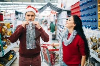 Couple buying christmas costume in supermarket, family tradition. December shopping of new year holiday goods and decorations