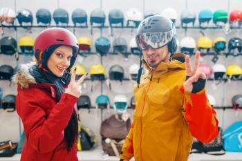 Young couple in helmets for ski or snowboarding, sports shop. Winter season extreme lifestyle, active leisure store, buyers choosing protect equipment