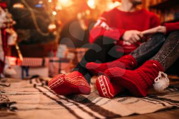Love couple happy together, christmas holidays. Xmas celebration, man and woman sitting on the floor, boxes with gifts on background