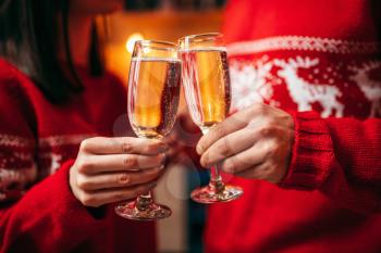Love couple holds glasses with champagne, romantic christmas celebration. Man and woman celebrate xmas together