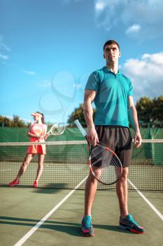 Man and woman plays tennis on open air. Summer season sport game. Active lifestyle