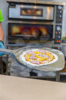 Baker hands with shovel, cooking pizza, electric ovens