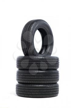 Pile of unused car tires isolated on white background. Tyre service or shop advertising