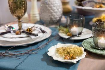 Table decorated with luxury dishes closeup, nobody. Plates served with acorn. Holiday celebration